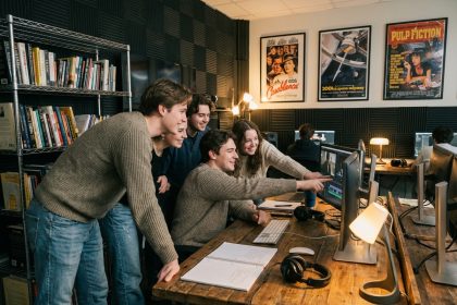 Groupe d'&eacute;tudiants en film critique un projet dans une salle de classe